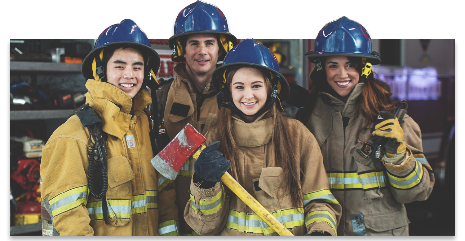 Two older teenagers are smiling while wear firefighting uniforms